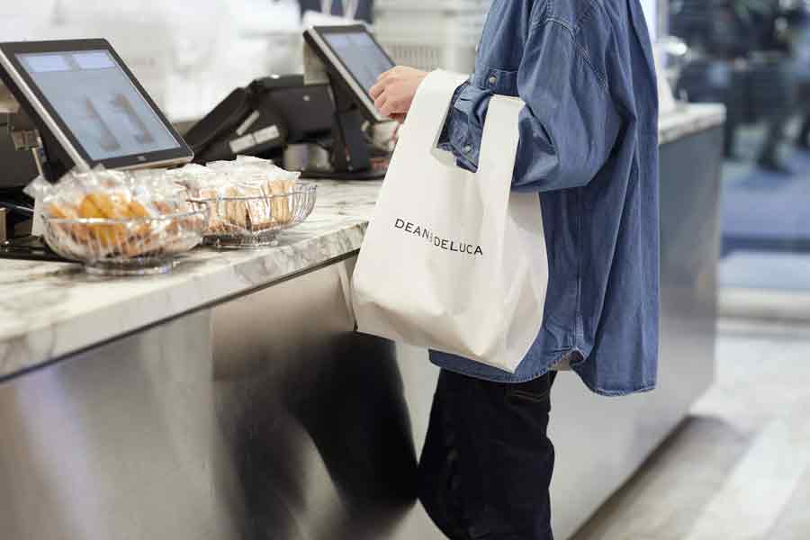 DEAN & DELUCAのエコバッグを持ったレジ前の女性