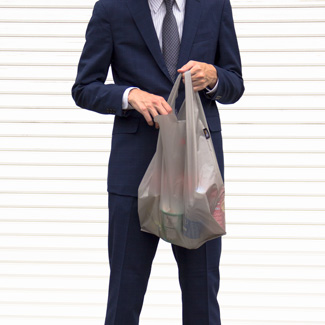 エコバッグを使うスーツを着た男性