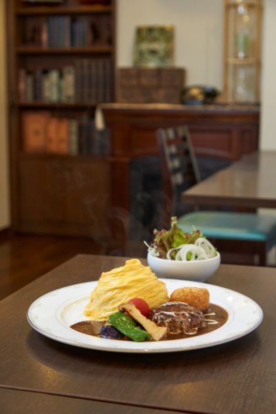 出来立てで湯気がたつドレープされたオムライスとハンバーグとコロッケ