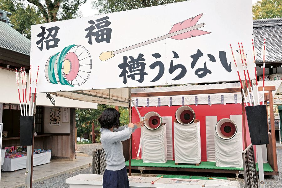 樽に矢を放つ女性