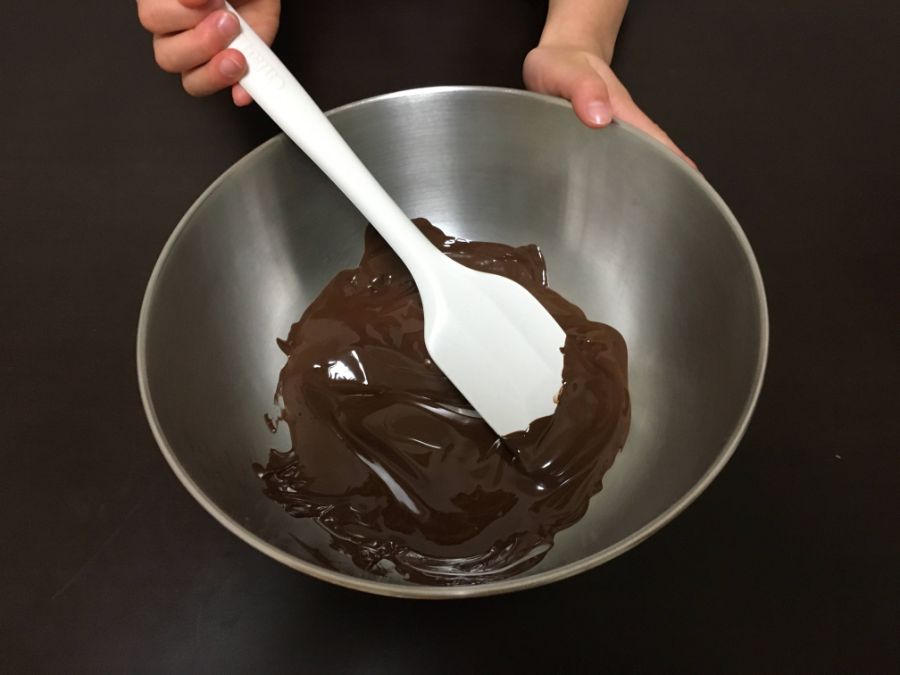湯煎したチョコレートをゴムベラで混ぜる様子