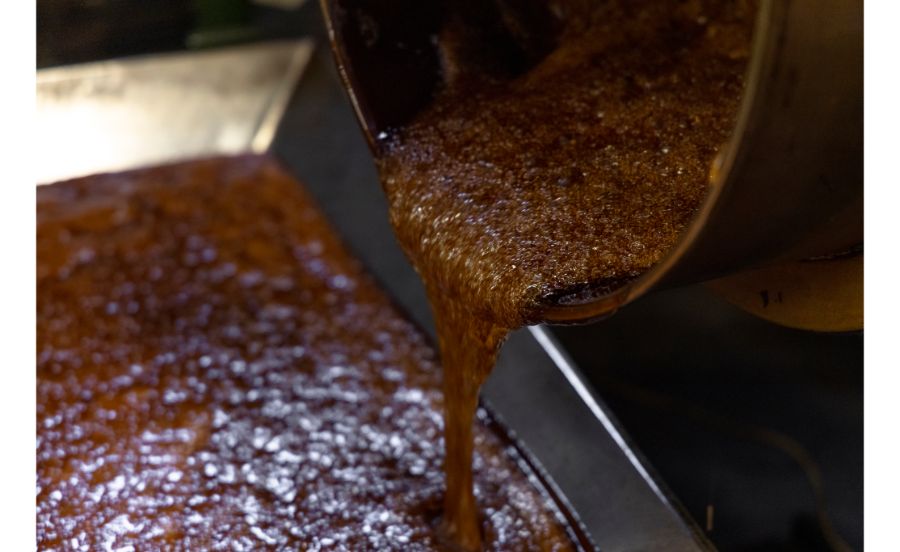 窯で炊いた飴を冷却台に流しているところ