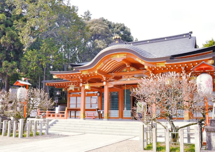 朱色の社殿と脇の梅