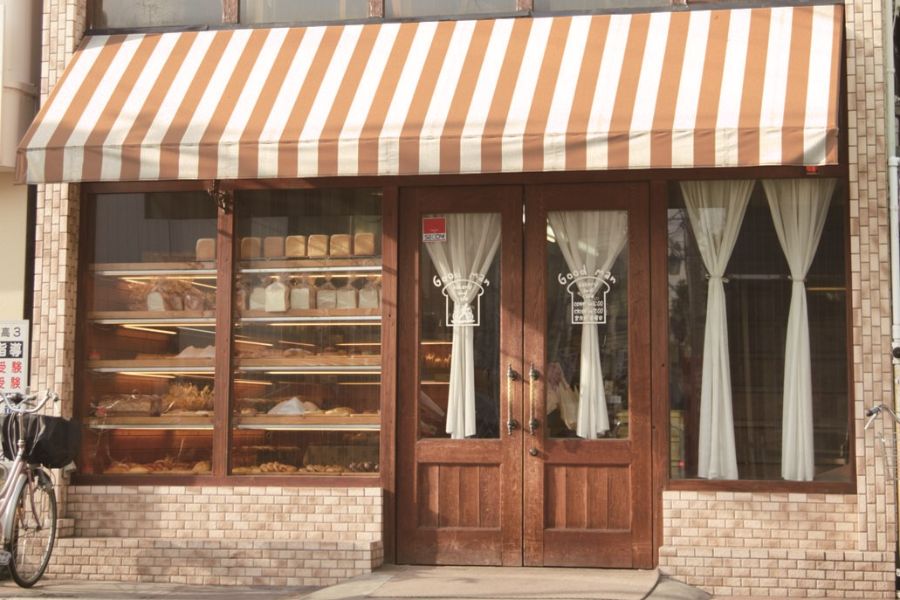 茶色と白のストライプのひさしがお洒落なグッドマンの外観