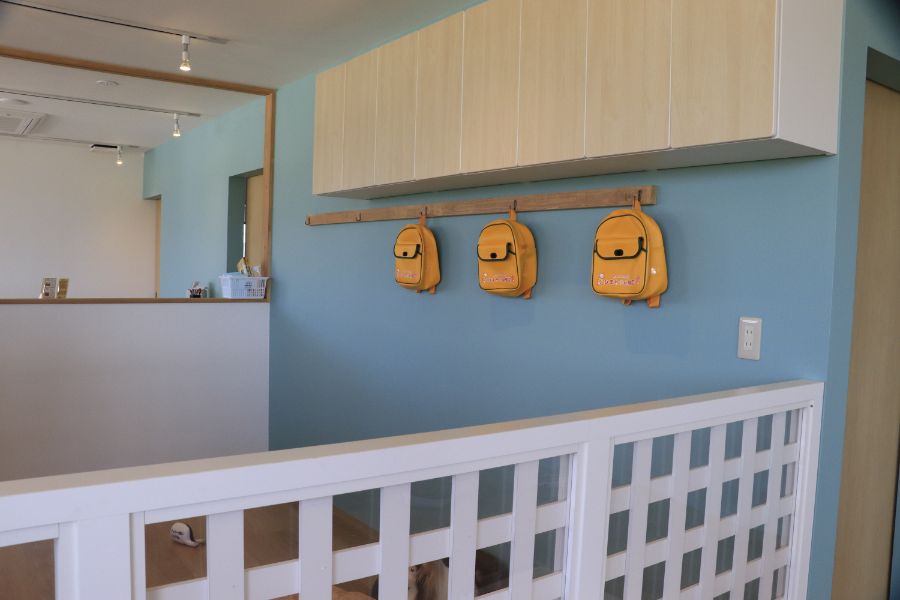 幼稚園の壁にかかる黄色いリュック