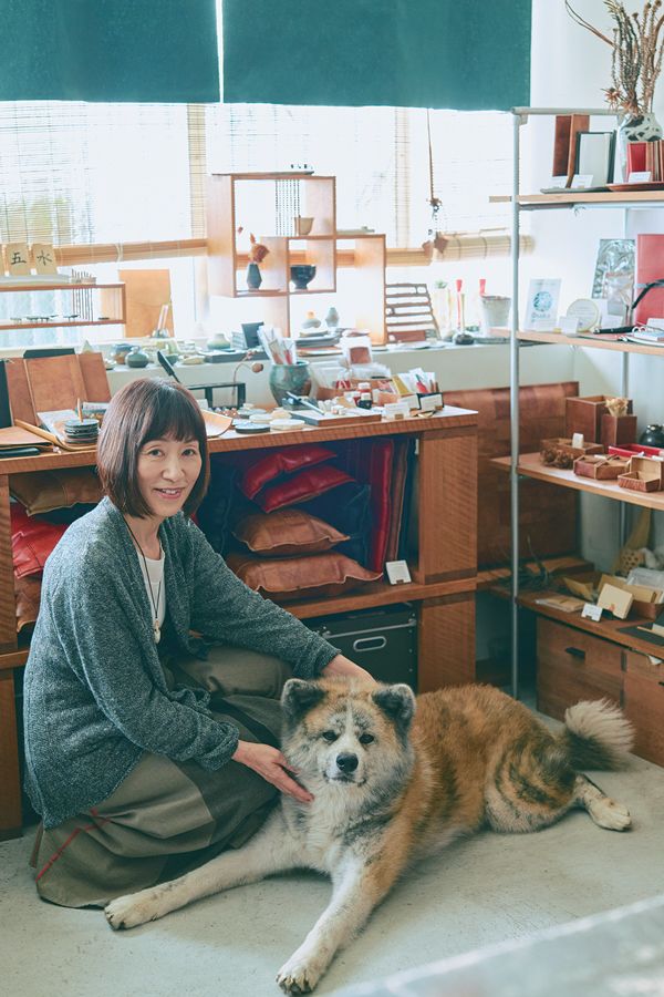 秋田犬に手を添えるオーナーの女性