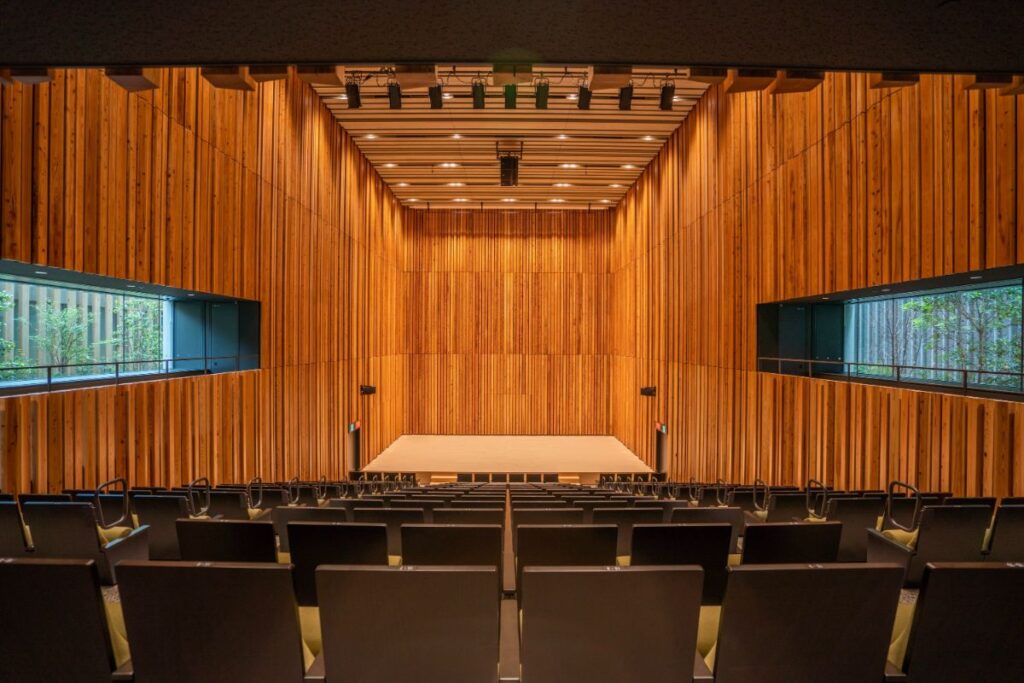 木ルーバーとサイドバルコニーからの緑が美しい小ホール