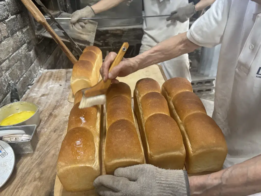 食パンの表面に刷毛でバターを塗る様子