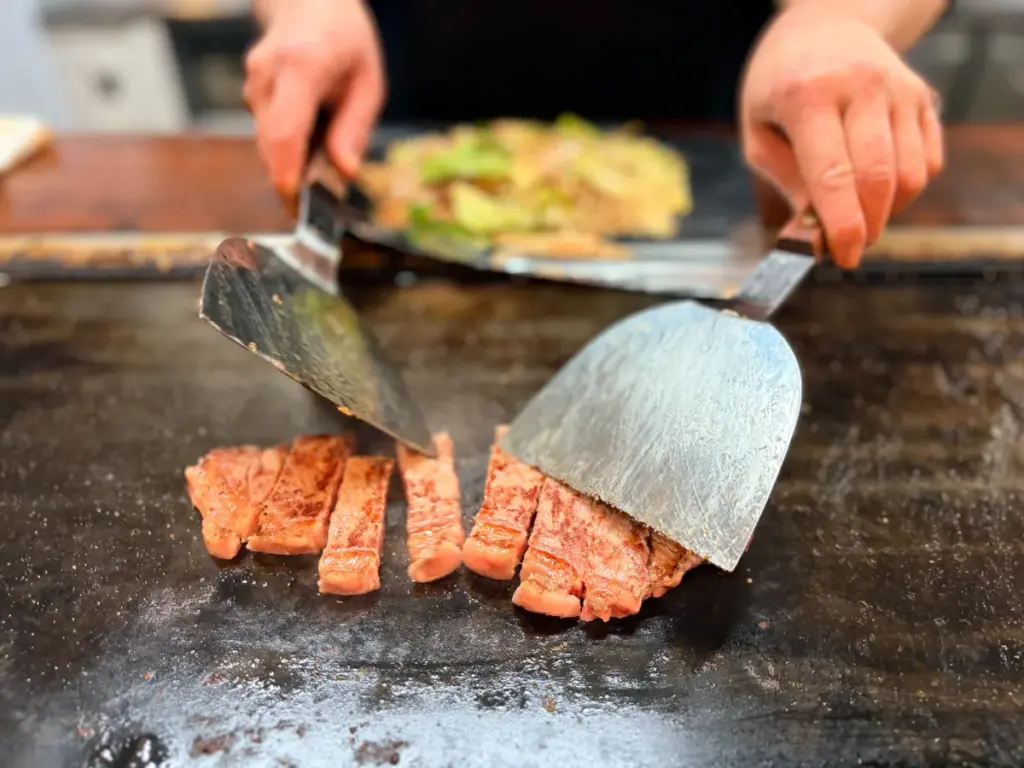 「お好み鉄板 武庫之荘」の牛肉を焼くシーン