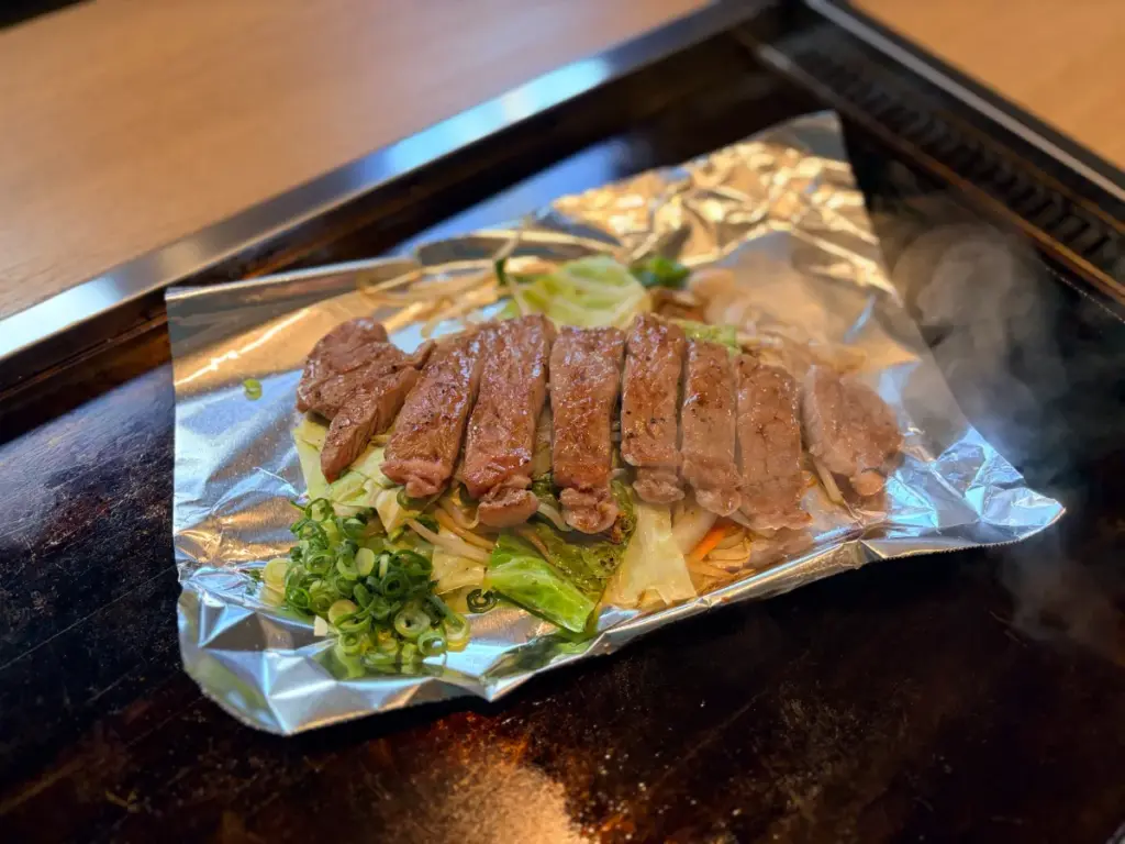 「お好み鉄板 武庫之荘」の鉄板の上のステーキ