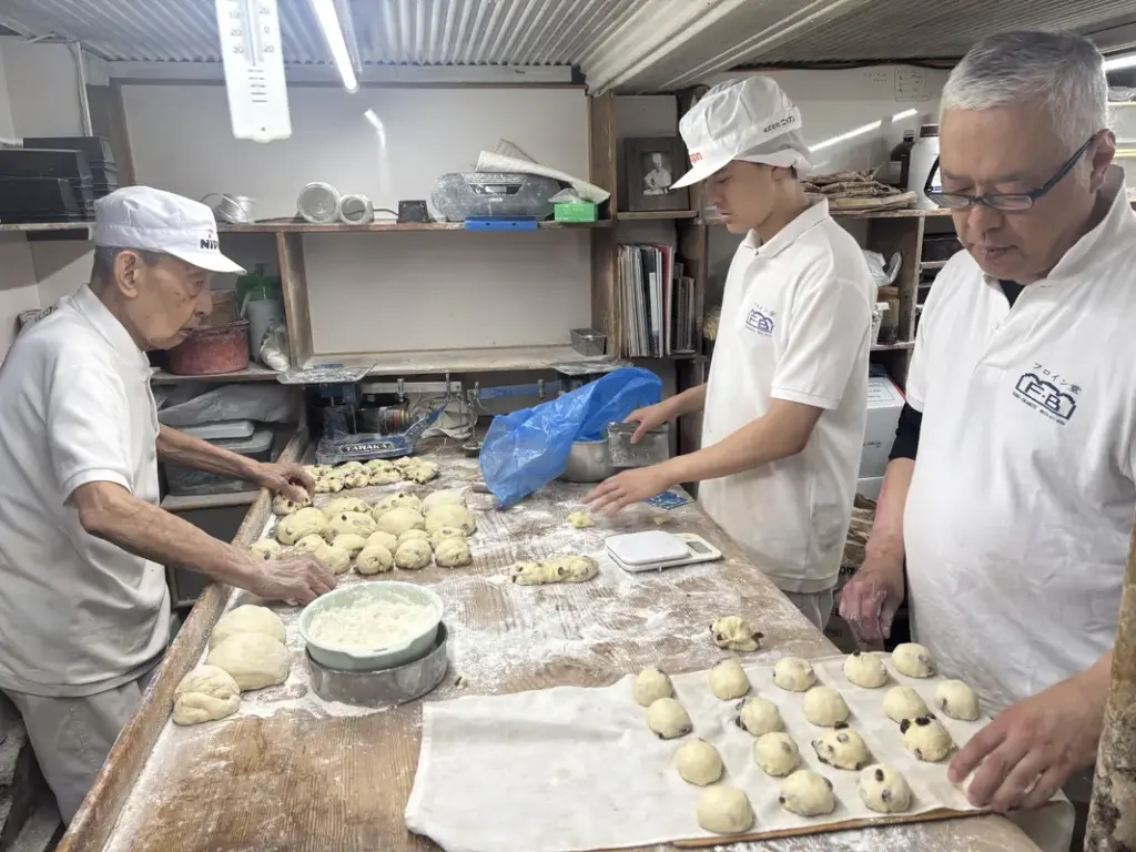 パンを作る2代目の竹内善之さんと息子さんの隆さん、お孫さんの陸人さん