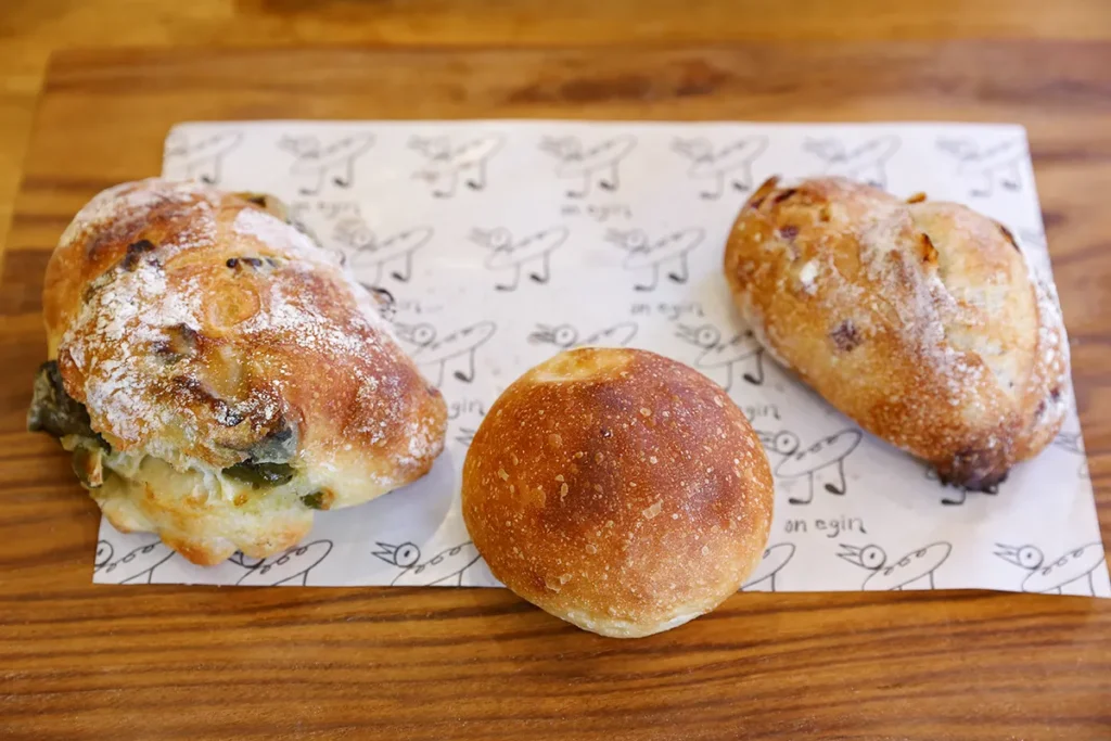 写真左から「リュスティック(万願寺唐辛子入り)」280円、「塩パン」100円、「クランベリーオレンジ」280円