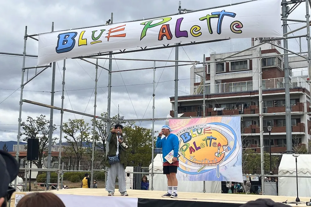 ブルーパレットのステージにて司会の方とヤナギブソンさん