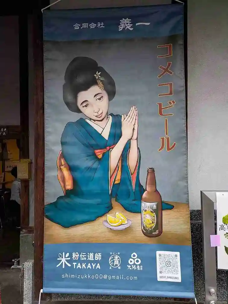 着物を着た女性と清水っ粉レモンクラフトビールのイラストが描かれ、「コメコビール」と書かれた大きなのぼり