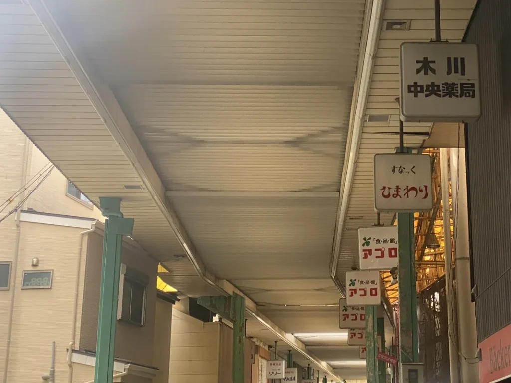 「食品館アプロ木川店」の看板が並ぶ商店街