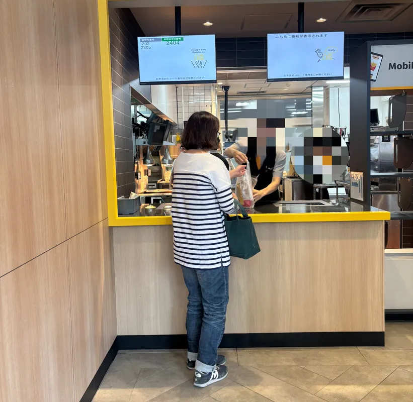 カウンターで商品を受け取る人